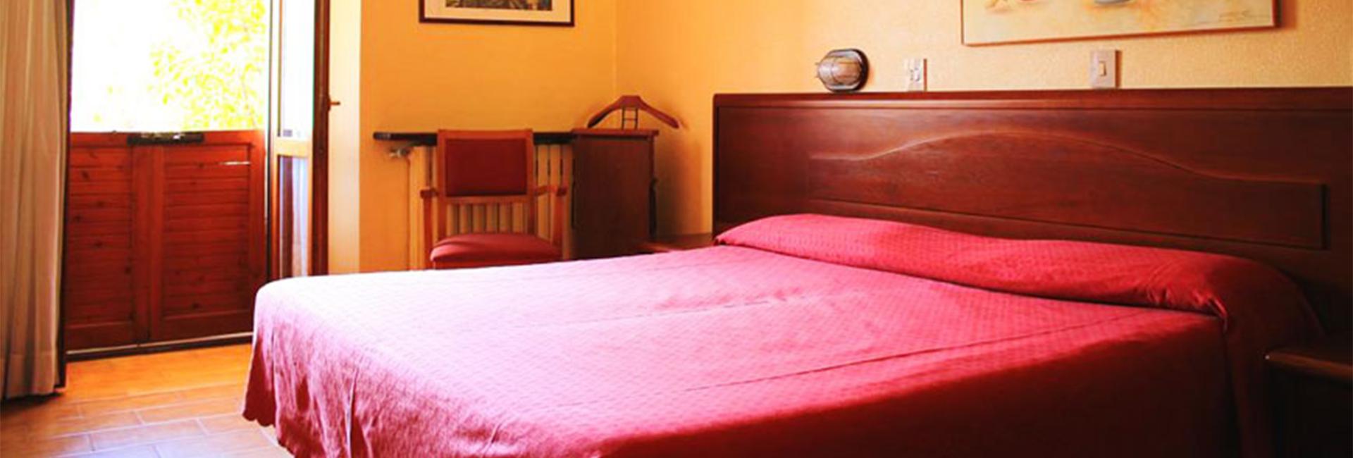 Camera da letto con letto matrimoniale, arte murale e porta finestra aperta.