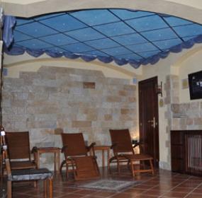 Sala relax con sedie a sdraio, pareti in pietra e soffitto blu stellato.