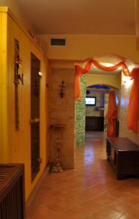 Corridoio con decorazioni arancioni, pavimento in piastrelle e arredi in legno.