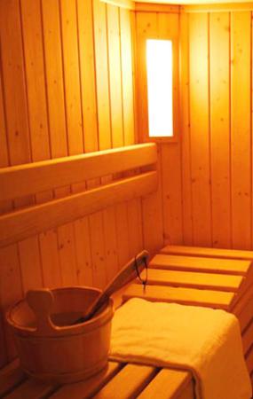 Interno di una sauna con panche in legno e secchio con mestolo.