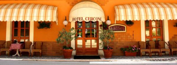 Facciata dell'Hotel Cercone con tende a strisce e piante ornamentali.