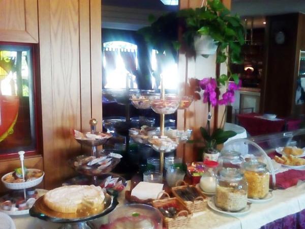 Buffet con dolci, cereali e decorazioni floreali in un ambiente accogliente.