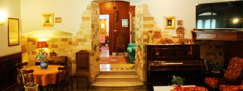 Sala accogliente con pianoforte, arredi classici e decorazioni eleganti.